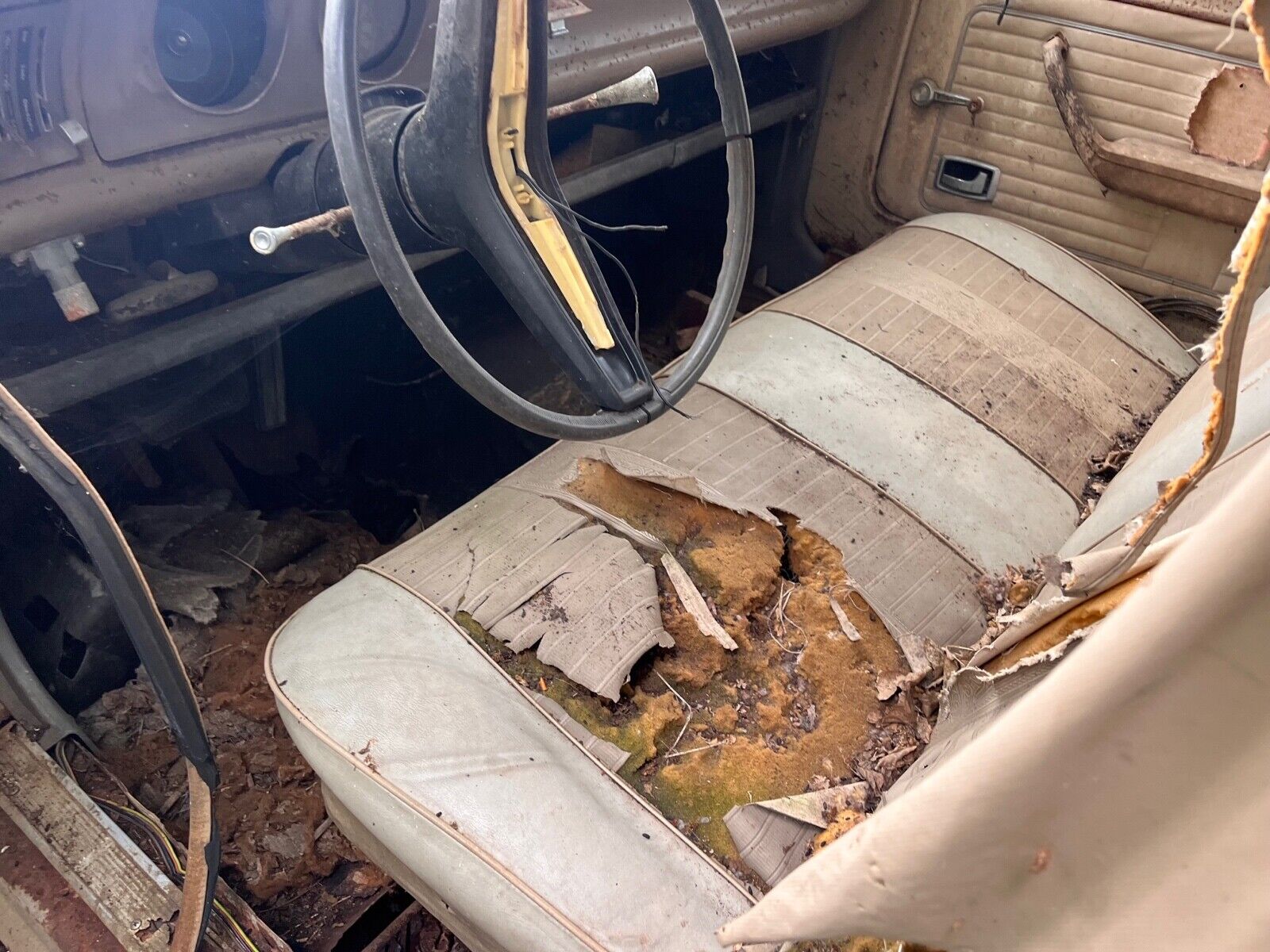 this 1973 ford was forgotten in a barn that fell apart now abandoned in the woods 12